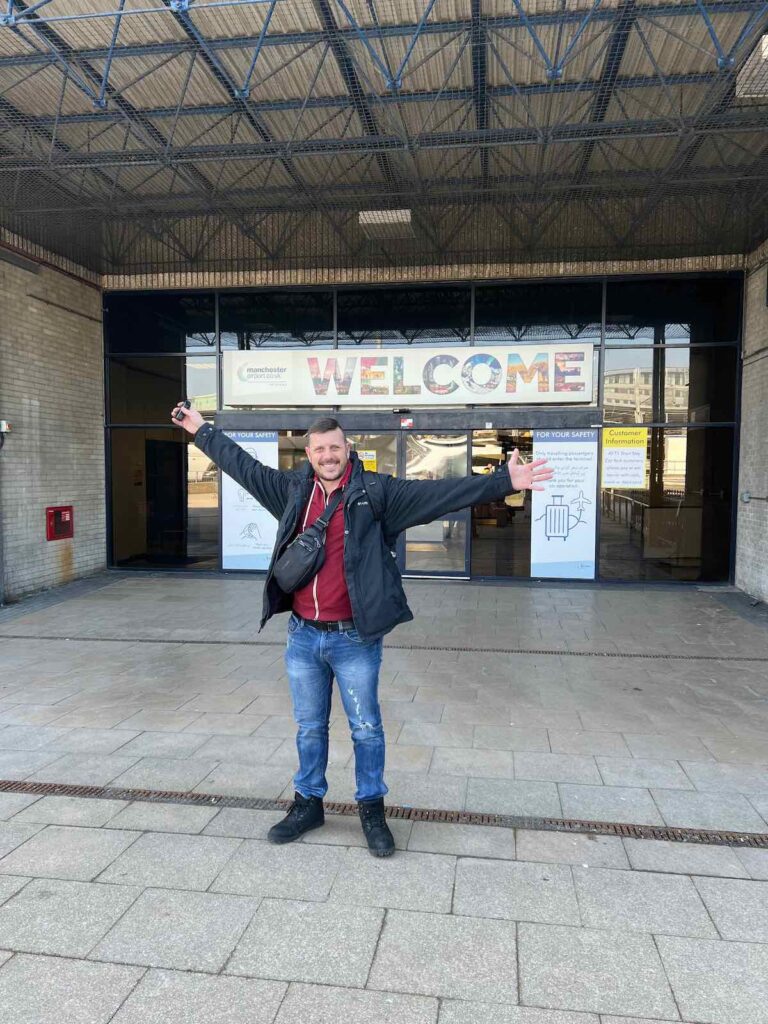 Trevor outside of the arrivals door at Manchester airport