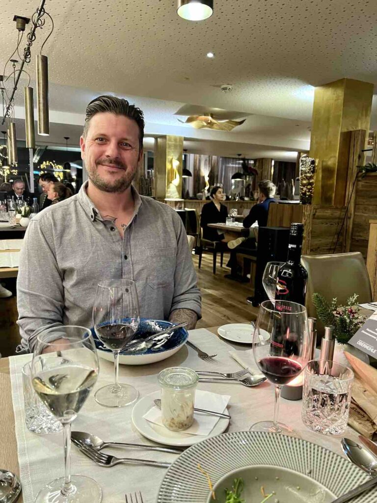 Trevor smiling, sitting in the restaurant at Obermühle Alpin Spa Resort
