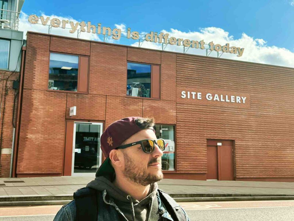Trevor in front of a "everything is different today" sign in Sheffield