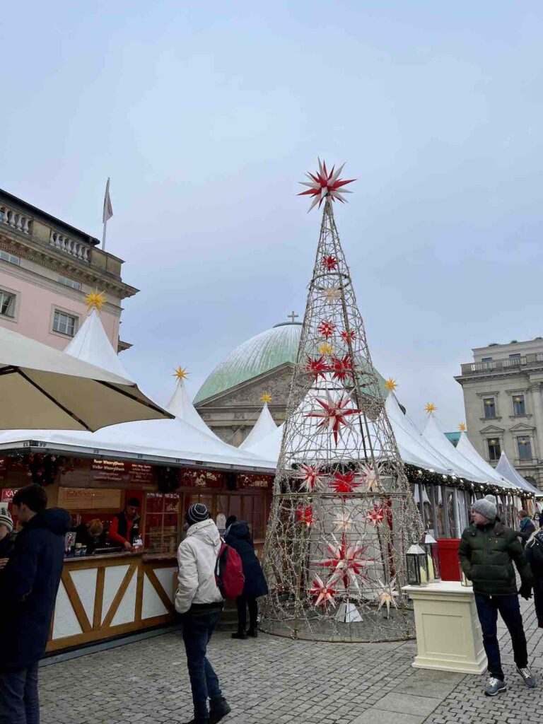 Bebelplatz Christmas Market in Berlin. Beautiful buildings in the background of a steel decorated tree.