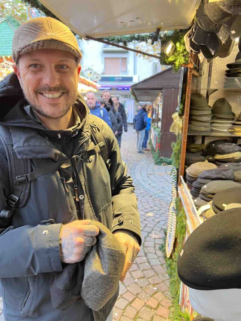 Trevor trying on a flat cap at Paulsplatz Christmas Market 